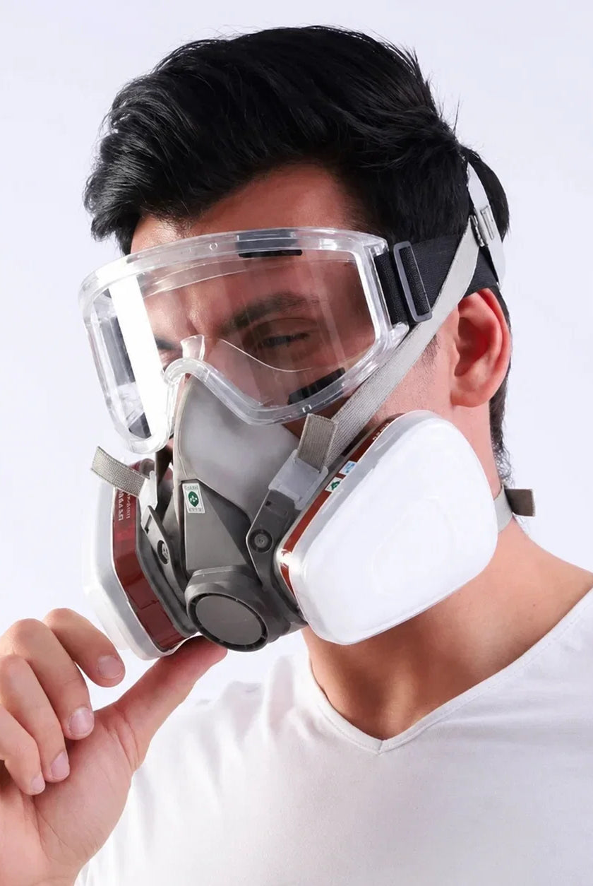 Man wearing half face respirator with safety goggles for oxalic acid vaporization beekeeping